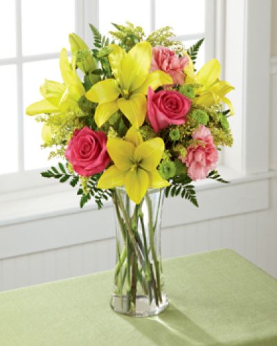 <p>Light, lovely, and set to surprise and delight your recipient with it's bright blooms, this flower bouquet speaks to the magic that each day holds. Brilliant yellow Asiatic Lilies are surrounded by hot pink roses, pink carnations, yellow solidago, and lush greens, beautifully arranged in a classic clear glass vase to create a gift that exudes warmth and happiness. A wonderful way to celebrate a birthday, or express your thank you, or congratulations wishes!</p>