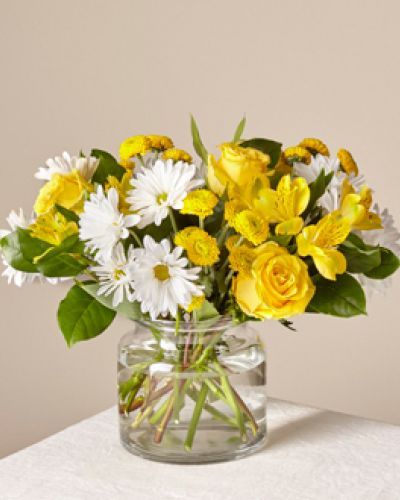 <p>This sun-kissed assortment of white and yellow blooms brightens the room with radiance. Whether you want to boost someone’s mood or send happiness, this bouquet is just the right pick.</p>