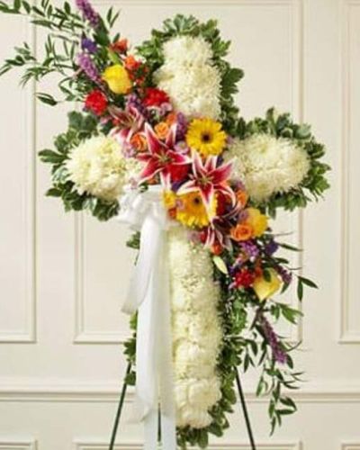 <p>A solid white standing cross with a bright flower break, this beautiful floral tribute shows your compassion, faith and love during this difficult time. The arrangement is created from fresh white mums and bright-colored roses, lilies, Gerbera daisies, carnations and more. Traditionally sent directly to the funeral home by family members or friends and displayed on a stand.</p>