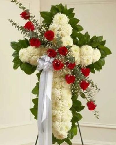 <p>This beautiful floral tribute shows your faith, hope and love during this difficult time. This standing spray arrangement in the shape of a cross is created from fresh white mums, red roses, spiral eucalyptus and more. Traditionally sent directly to the funeral home by family members or friends and displayed on a stand.</p>