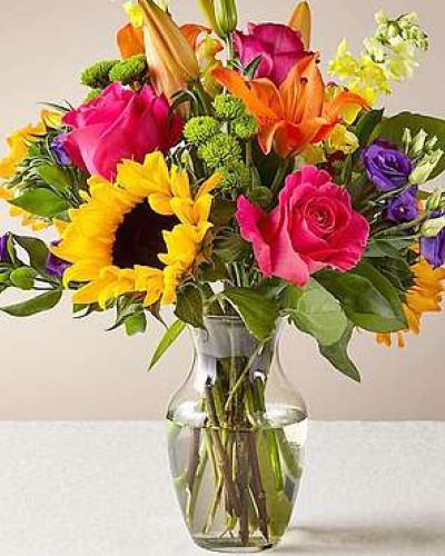 The Best Day™ Bouquet is ready to create a moment your recipient will always remember! An instant mood booster with it's mix of bright bold colors, this gorgeous fresh flower arrangement brings together sunflowers, hot pink roses, purple double lisianthus, orange LA Hybrid Lilies, yellow snapdragons, green button poms, and lush greens to make this day, their best day. Presented in a clear glass vase, this fresh flower arrangement is made just for you to help you send your warmest birthday, congratulations, or get well wishes to your favorite friends and family.