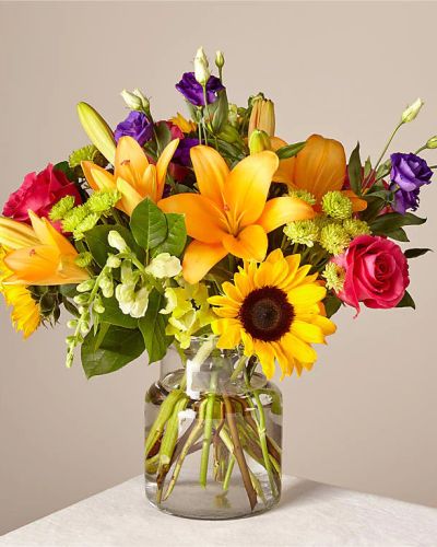 <p>Make this day their best day. Our local florist handcraft a colorful array of flowers in a clear glass vase to create a celebration in bloom. Perfect to give for a special reason or to simply share a smile.</p>