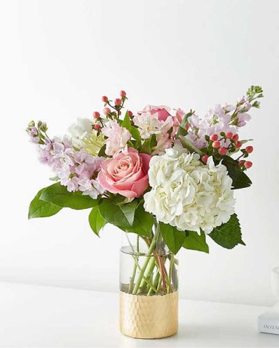 Tickle them pink with this elegant arrangement of roses, alstroemeria, hypericum berries, and carnations set in a gold–dipped vase. As elegant as a string of pearls, add a touch of class to any room with roses and gerbera daisies.